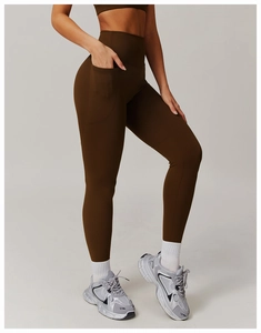 Détail du legging de sport marron foncé à taille haute avec poche latérale pour téléphone
