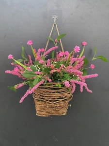 Detail of pink berry and wildflower hanging basket with rustic woven rattan base