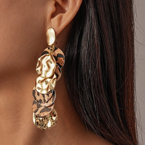 Detail of layered gold hammered metal and leopard print circular boho drop earrings