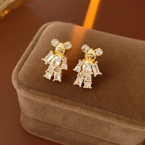 Close-up of gold plated bear stud earrings with sparkling cubic zirconia on velvet