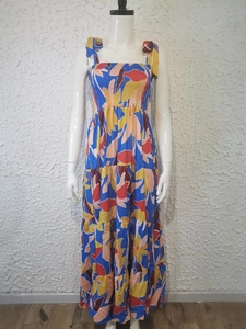 Detail view of tropical floral print maxi dress featuring tie straps and tiered hemline