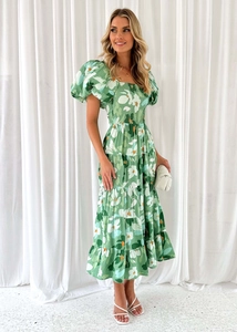 Dettaglio del vestito a fiori verdi con maniche a sbuffo e gonna a balze a più livelli