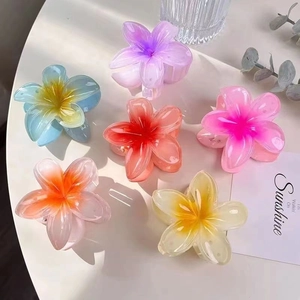 Flat lay of six colorful bauhinia flower hair claws in purple, blue, and pink resin