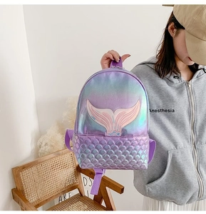 Detail of laser shiny mermaid scales texture and embroidery on pink gradient backpack