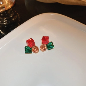 Vue macro de boucles d'oreilles géométriques en cristal avec pierres rouges, vertes et champagne