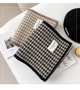 Detail of knitted houndstooth scarf with personalized woven label and soft texture