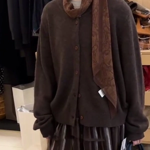 Close-up of deep brown knit cardigan with vintage paisley scarf and grey striped skirt