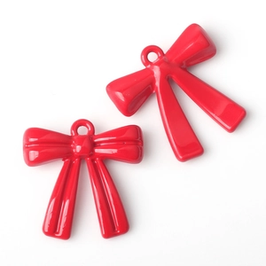 Detail view of two glossy red resin bow pendants for DIY jewelry making accessories