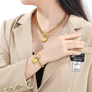 Dettaglio di un set di collana e bracciale con pendente a cuore dorato su una modella