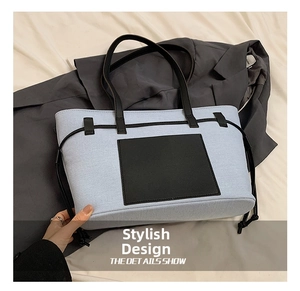Detailansicht der hellblauen Canvas-Tasche mit schwarzem Ledergriff und Fronttasche