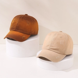 Detail view of distressed washed cotton baseball caps with vintage frayed edges and holes