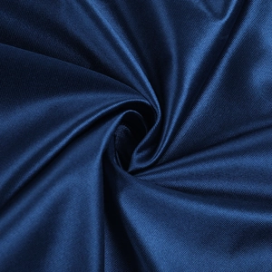 Close-up of deep blue satin fabric with silky texture and elegant ribbed spiral draping