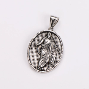 Close-up of a silver oval stainless steel pendant with embossed vintage figure detail