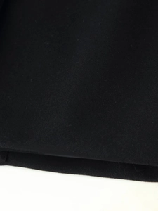 Close-up of black wool fabric texture showing detailed fiber weave for long coats