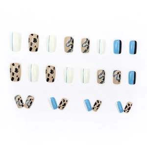 Short faux nails with blue, white, and cow print patterns for a trendy autumn look