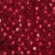 Vista macro di paillettes circolari rosso scuro ad alta densità con riflesso metallico