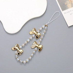 Close-up of crystal square beads and golden bow detail on a stylish phone wrist strap