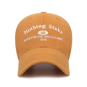 Front view of mustard yellow baseball cap with vintage white embroidered lettering