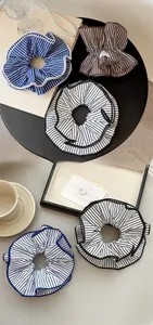 Detailed view of layered striped fabric scrunchies in blue, black, and brown patterns