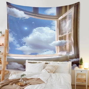 Detail of bohemian wall tapestry featuring blue sky, clouds and moon for bedroom decor