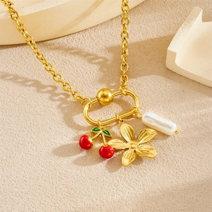 Gold plated necklace featuring red cherry, flower, and baroque pearl charms on O-chain
