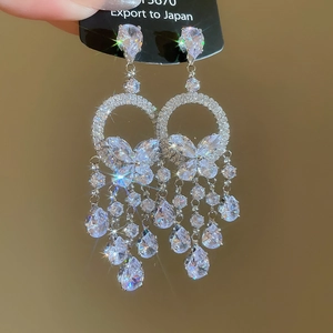 Détail de boucles d'oreilles à pampilles en argent avec zircons papillon et goutte d'eau