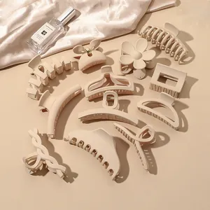 Close-up of assorted matte beige hair claws styled with silk fabric and warm light