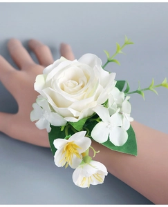 Détail d'un corsage de poignet de mariage en rose blanche artificielle avec feuilles