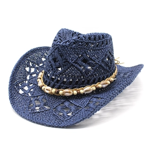 Détail d'un chapeau de cowboy bleu foncé tressé avec décorations en coquillage