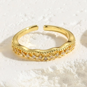 Detail of wavy adjustable ring band with sparkling cubic zirconia inlays in gold