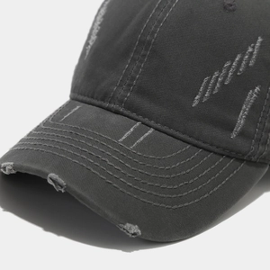 Detailed macro view of distressed washed cotton baseball cap with frayed brim edges