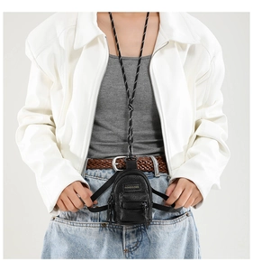 Close-up of black mini PU leather pouch with fashion label and striped lanyard detail