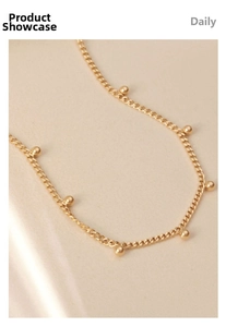 Macro view of 18K gold plated stainless steel chain with polished gold beads