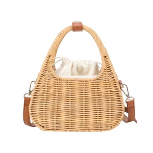 Handmade woven rattan crossbody bag with brown leather handles and canvas drawstring liner
