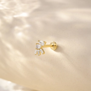 Macro view of gold cartilage stud featuring fan-shaped clear zircon and screw thread detail
