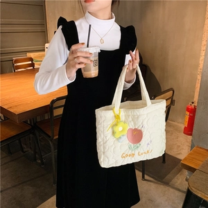 Detailed view of quilted tote bag with colorful tulip embroidery and Good Luck text