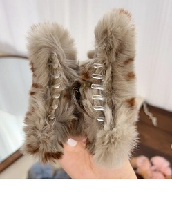 Close-up of grey and brown spotted plush hair claw clip with transparent inner teeth