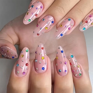 Almond press-on nails with colorful rhinestones and nude pink translucent base