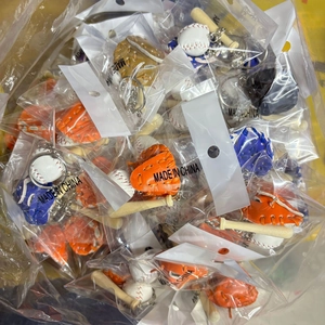 Detail of bulk baseball keychains featuring a wooden bat, white ball, and colorful glove