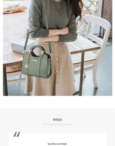 Detail of green leather handbag featuring golden circular handles and star charm pendant