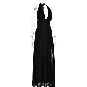 Detail of a black halter neck long dress featuring a high side slit and soft flowing fabric