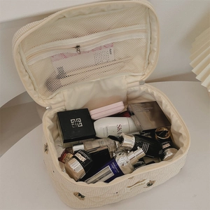Detail view of corduroy vanity case with flower embroidery and inner mesh pocket