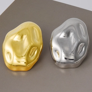 Detail of irregular liquid lava style earrings in 18k gold and silver finish metal