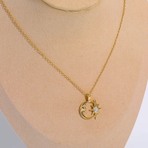 Minimalistische Goldkette mit Mond-Stern-Opal-Anhänger auf einem Display-Ständer