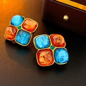 Vue macro de boucles d'oreilles vintage avec pierres bleues et orange sur cuir