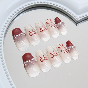 Faux ongles rouge vin avec perles, nœuds et paillettes argentées forme cercueil élégante