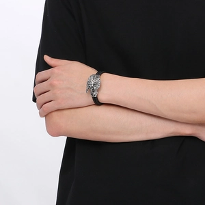 Close-up of a braided black leather bracelet with a detailed Indian skull metal buckle