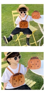 Detailed view of kids vintage ladybug backpacks in brown leather during outdoor shoot