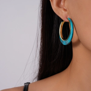 Close-up of model wearing geometric marble-textured hoop earrings with gold-toned inner rim