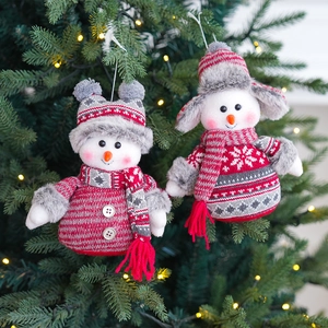 Charming red and white plush snowman ornaments hanging on a festive Christmas tree